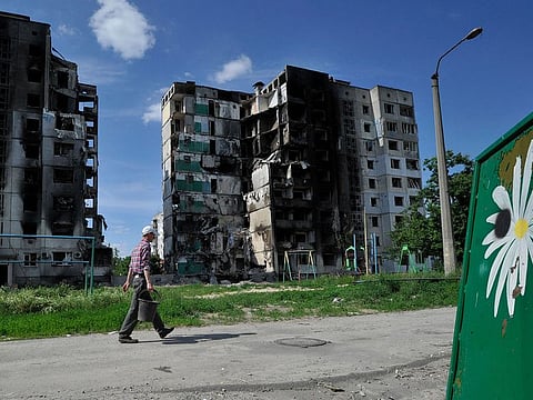 A local resident walks by a destroyed apartment building in the town of Borodyanka on June 7, 2022, amid the Russian invasion of Ukraine.