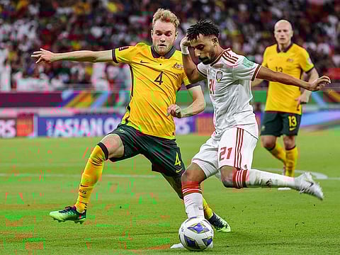Australia's defender Nathaniel Atkinson (left) vies for the ball against UAE's forward Harib al-Maazmi during the FIFA World Cup 2022 play-off qualifier at Ahmad bin Ali stadium in Doha.