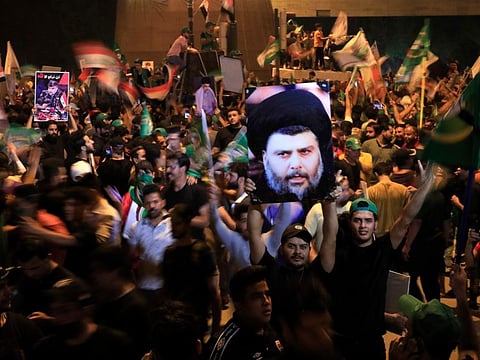 Followers of Shiite cleric Muqtada Al Sadr, on the poster, celebrate after the announcement of the results of the parliamentary elections in Tahrir Square, Baghdad on October 11, 2021. Eight months after national elections, Iraq still doesn't have a government.