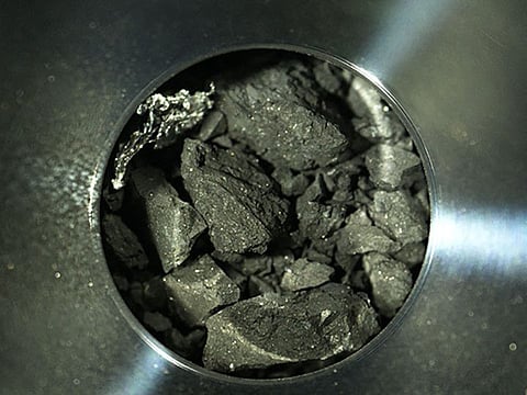 This file handout photograph released by the Japan Aerospace Exploration Agency (JAXA) on December 24, 2020 shows samples of soil from the asteroid Ryugu, inside C compartment of the capsule collected by the Hayabusa-2 space probe, at JAXA Sagamihara Campus in Sagamihara, Kanagawa prefecture.