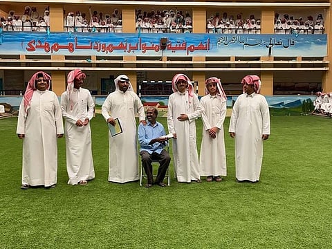 The worker is seated as he is feted at the school.