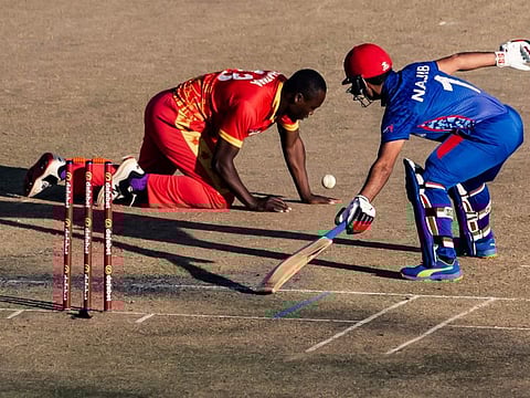 Afghanistan's Najibullah Zadran (right) gets back safe in his crease as Zimbabwe's Tendai Chatara fields during the first T20 international at the Harare Sports Club in Harare.