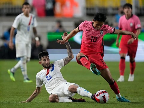 South Korea's Jeong Woo-yeong (right) is tackled by Paraguay's Mathias Villasanti during their friendly match at Suwon World Cup stadium in Suwon, South Korea.