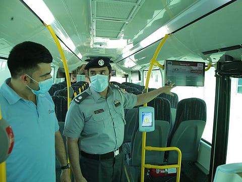 Policeman explains about the the newly installed screens on public buses in Abu Dhabi to raise community awareness about various topics of public safety.