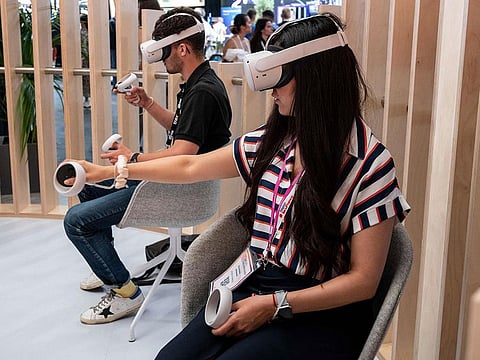 Attendees try out a Meta virtual reality headset during the Vivatech technology startups and innovation fair in Paris