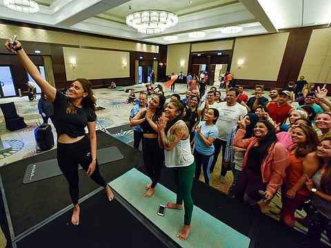 Sisters Anushka (L) and Akansha (second from left) take a group selfie with participants