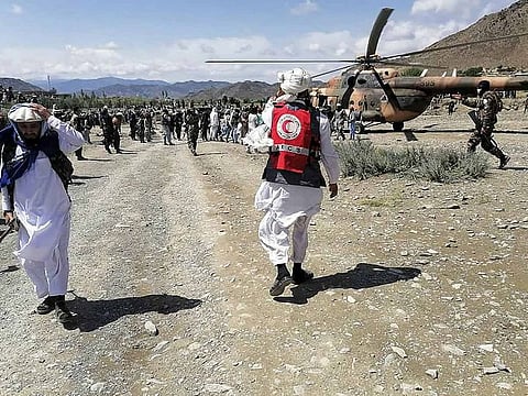 Soldiers and Afghan Red Crescent Society officials near a helicopter at an earthquake hit area in Afghanistan's Gayan district, Paktika province.