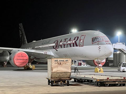 A file photo of an Airbus A350 jet sitting idle with its windows taped and engines covered in a floodlit hangar.