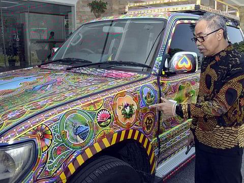 Ambassador of Indonesia to Pakistan Adam Tugio showing various landmarks of his homeland that he got painted on his official automobile.