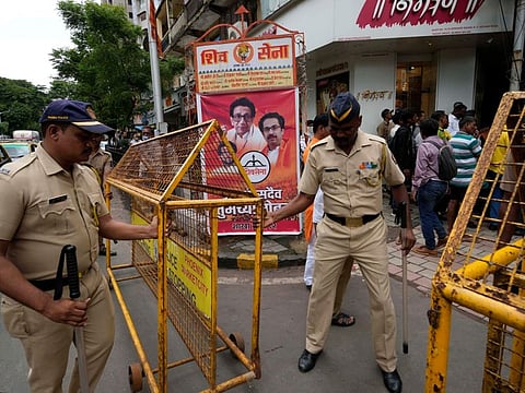 Police officers put a barricade outside Shiv Sena Bhawan, the party headquarters, in Mumbai, India, Friday, June 24, 2022.