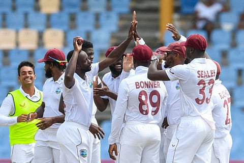 Kemar Roach and his West Indies teammates celebrate his 250th Test wicket at Darren Sammy Cricket Ground in Gros Islet, Saint Lucia.