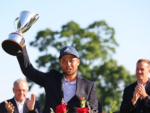 Xander Schauffele of the United States poses with the trophy after putting in to win on the 18th green during the final round of Travelers Championship at TPC River Highlands in Cromwell, Connecticut.