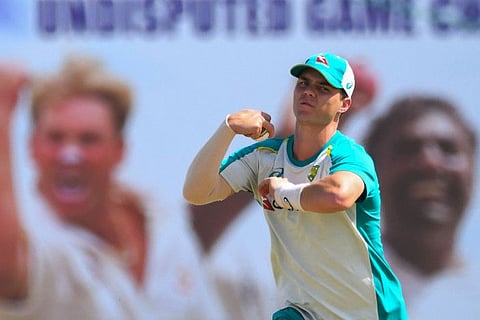 Australia's Mitchell Swepson delivers a ball during a practice session, in front of a photo of legends Shane Warne and Muttiah Muralitharan, at the Galle International Cricket Stadium on Tuesday.