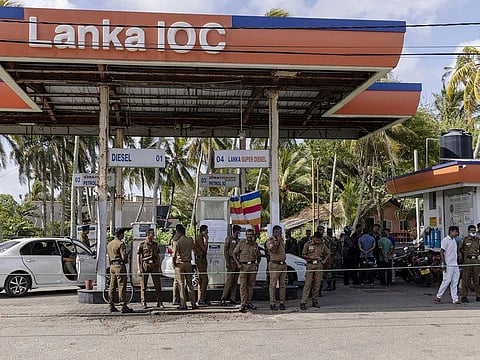 Police officers guard a gas station closed due to lack of supplies in Galle, Sri Lanka, on Tuesday, June 28, 2022.