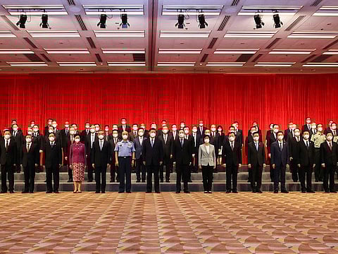 In this photo released by Xinhua News Agency, Chinese President Xi Jinping, center front, poses for a photo with central government officials based in Hong Kong and senior executives of Hong Kong branches of mainland enterprises and institutions, in Hong Kong, Thursday, June 30, 2022.