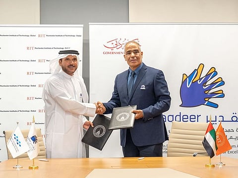 Major-General Obaid Muhair bin Suroor with an official during the signing of the memorandum of understanding.