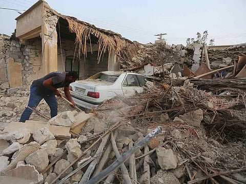 A man cleans up the rubble after an earthquake at Sayeh Khosh village in Hormozgan province, some 1,000km south of Tehran, Iran, on Saturday, following the earthquake.