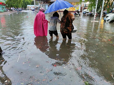 Pedestrians wade through floodwaters on a street amid heavy rainfall as Typhoon Chaba hits Sanya in Hainan province, China on July 2, 2022.