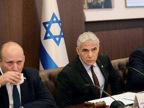 Israel's former Prime Minister Naftali Bennett (left) and interim Prime Minister Yair Lapid attend the first cabinet meeting after lawmakers dissolved the parliament, in Jerusalem on July 3, 2022.