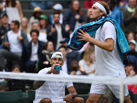Fiery encounter... Australia's Nick Kyrgios looks on as Greece's Stefanos Tsitsipas walks past during their men's singles tennis match on the sixth day of the 2022 Wimbledon Championships at The All England Tennis Club in Wimbledon, southwest London.