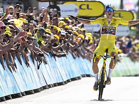 Jumbo-Visma team's Belgian rider Wout Van Aert celebrates as he cycles past the finish line to win the fourth stage of the 109th edition of the Tour de France cycling race on Tuesday.