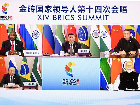 Chinese President Xi Jinping is seen on a screen with South African President Cyril Ramaphosa, Brazilian President Jair Bolsonaro, Russian President Vladimir Putin and Indian Prime Minister Narendra Modi as he hosts the 14th BRICS Summit via video link from Beijing on June 23, 2022. Xi Jinping opened a meeting of leaders of major developing countries by saying the world should oppose unilateral sanctions and efforts by some countries to maintain their political and military power.