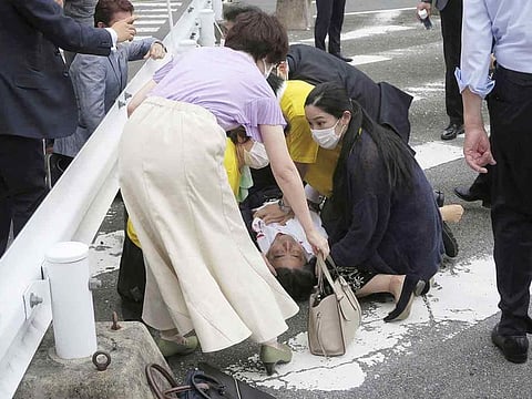 Former Japanese prime minister Shinzo Abe lies on the ground after after being shot during an election campaign for the July 10, 2022 Upper House election, in Nara, western Japan, on July 8, 2022.