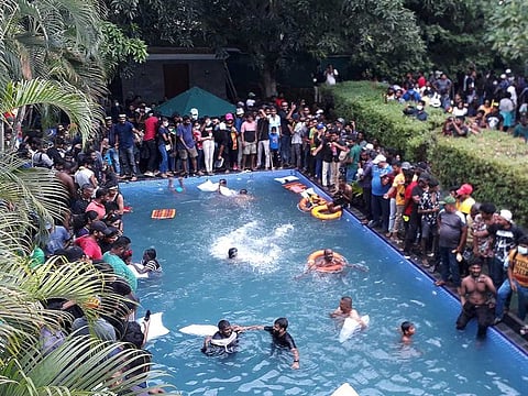 Protestors demanding the resignation of Sri Lanka's President Gotabaya Rajapaksa swim in a pool inside the compound of Sri Lanka's Presidential Palace in Colombo on July 9, 2022.