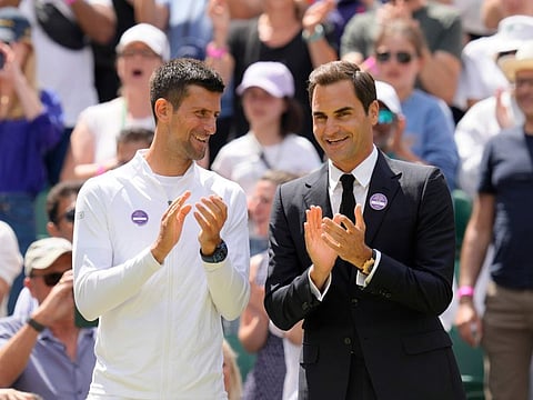 Serbia's Novak Djokovic and Switzerland's Roger Federer applaud during a 100 years of Centre Court celebration on day seven of the Wimbledon Championships in London on July 3.