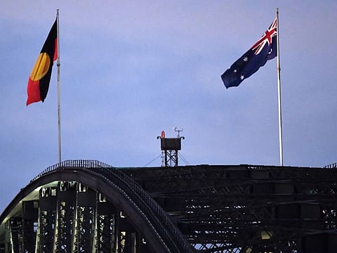 Australia's black, red and yellow Aboriginal flag flies beside Australia's national flag over the Harbour Bridge in Sydney on July 11, 2022.