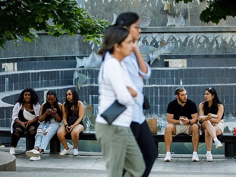 Fans sit outside the Rogers Centre after The Weeknd's Toronto show was postponed amid telecommunication company Rogers' service trouble, Friday, July 8, 2022.