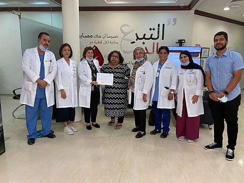 Gail D'Souza being handed over a certificate of appreciation by officials of the Dubai Blood Donation Centre for donating platelets 323 times from 2003 until she was diagnosed with cancer in 2019.