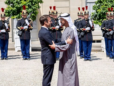 Sheikh Mohamed stands for a photograph with Emmanuel Macron and Brigitte Macron at the Elysee Palace.