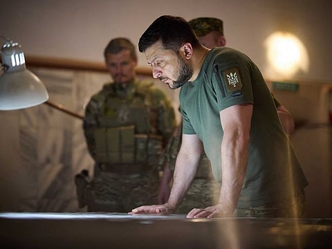 This handout picture taken and released by the Ukrainian Presidential press service on July 8, 2022 shows Ukraine President Volodymyr Zelensky looking at a map during his visit to the position of the Ukrainian army in Dnipro region.