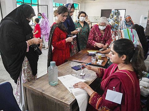Voters arrive to cast their ballot at a polling station during a by-election in Punjab province assembly seat in Lahore on July 17, 2022.
