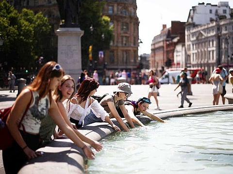 People cool off in a water fountain during a heatwave, at Trafalgar Square in London, Britain, July 19, 2022