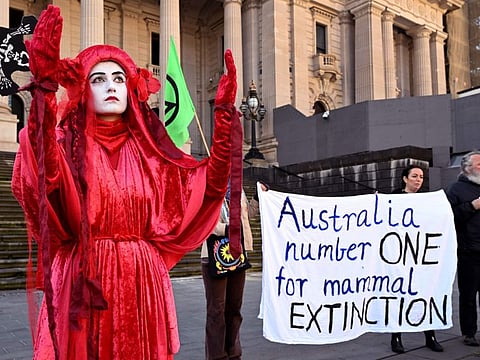 Extinction Rebellion members protest outside the State Parliament of Victoria in Melbourne on July 19, 2022, following the release of a government report on Australia's state of environment.
