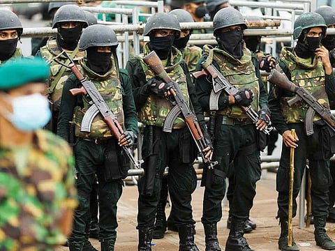 Security personnel stand guard near the Presidential Secretariat after a raid on an anti-government protest camp early on Friday, in Colombo.