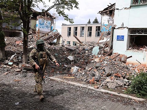 A Ukrainian serviceman passes by destroyed buildings in the Ukrainian town of Siversk, Donetsk region on July 22, 2022 amid the Russian attack of Ukraine.