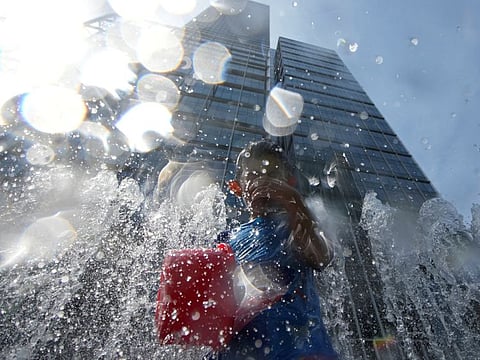 A child cools off in a fountain, amid a heatwave warning in Shanghai, China July 23, 2022.