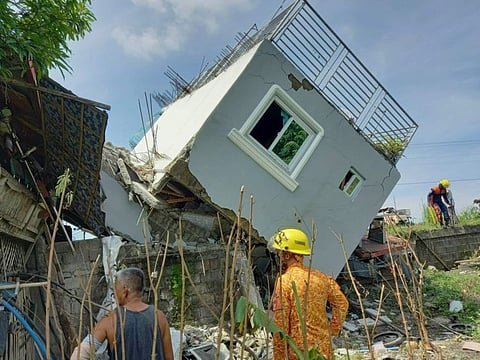 Rescuers check on a damaged house after a strong earthquake struck Santiago, Ilocos Sur province, Philippines, on Wednesday.