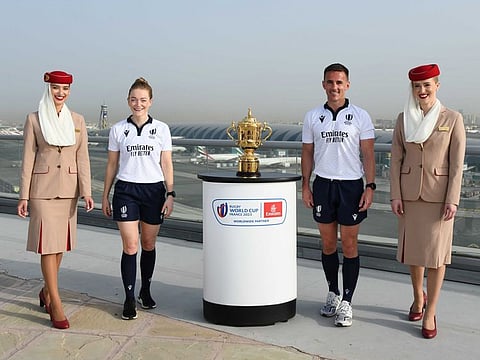 Emirates Crew and World Rugby Match Officials Hollie Davidson and Luke Pearce with the Webb Ellis Trophy.
