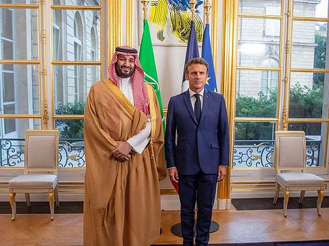 A handout picture provided by the Saudi Royal Palace shows French President Emmanuel Macron welcoming Saudi Crown Prince Mohammed bin Salman in Paris on July 28, 2022.