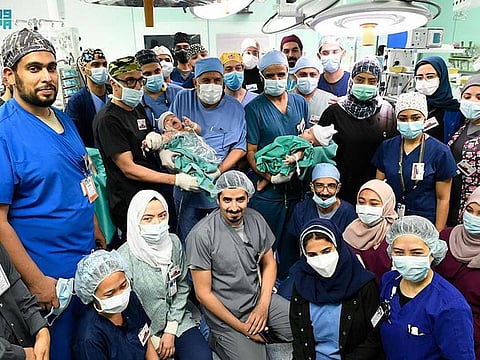 The medical team pose with the twins after the separation operation.