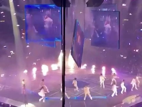 In this image made from video taken from social media, a video screen suspended above the stage falls onto the stage where dancers perform at a concert of Cantopop boy band Mirror in Hong Kong, Thursday, July 28, 2022.