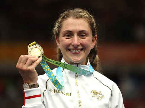 Gold medal winner Laura Kenny of England celebrates on the podium after the women's 10km scratch race final during the Commonwealth Games track cycling at Lee Valley VeloPark in London on Monday.