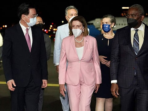 US House Speaker Nancy Pelosi, center, walks with Taiwan's Foreign Minister Joseph Wu, left, as she arrives in Taipei, Taiwan, Tuesday, Aug. 2, 2022.