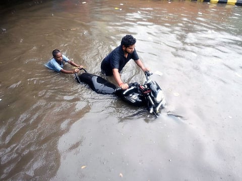 People push a motorcycle through a waterlogged road following heavy rainfall, in Prayagraj in Uttar Pradesh. Several states are lashed by heavy rains