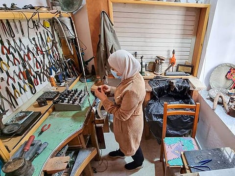 A Libyan woman crafts traditional filigree jewellery at a workshop in the capital Tripoli. Beads and threads of precious materials are woven into intricate designs, then soldered together to create jewellery. AFP