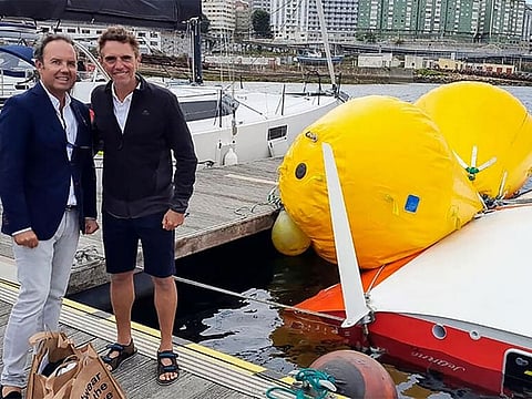 French sailor Laurent Camprubi, 62, poses with one of his rescuers after he survived 16 hours under his capsized sailboat off Spain